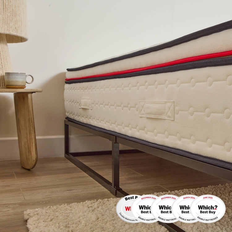 Beige mattress on a metal bed frame with 'Which?' award badges in a bedroom setting.