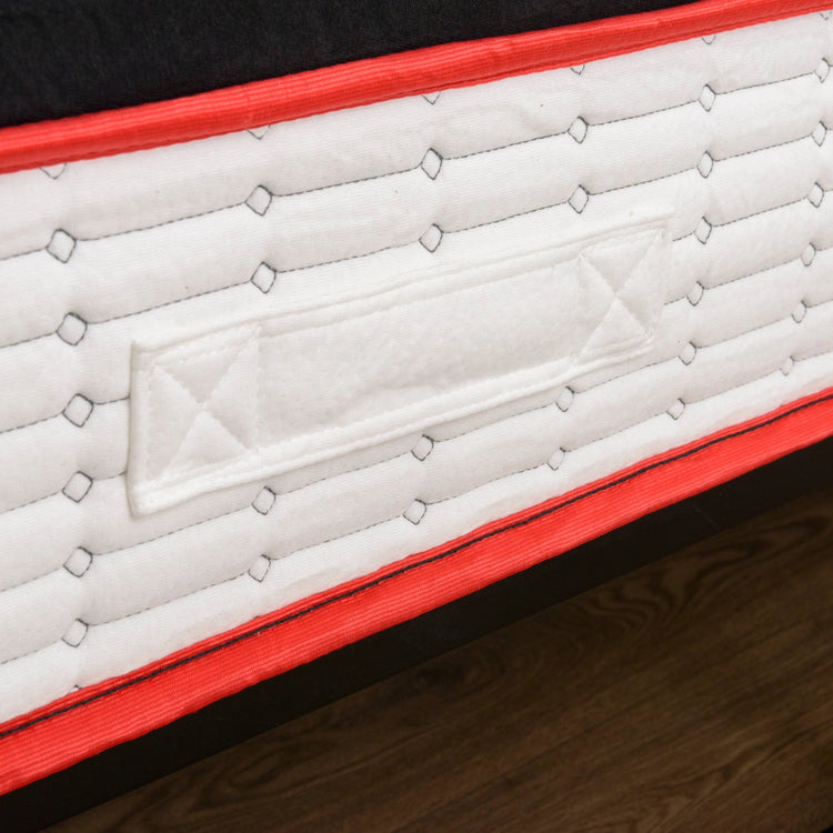 Close-up of a white eze mattress with handles, red border on a wooden floor