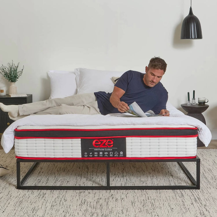 Man lying on a bed with a mattress branded 'EZE' in a bedroom setting