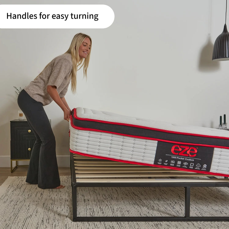 Woman lifting a mattress with handles showing the ease of turning with 'eze' branding in a room setting.