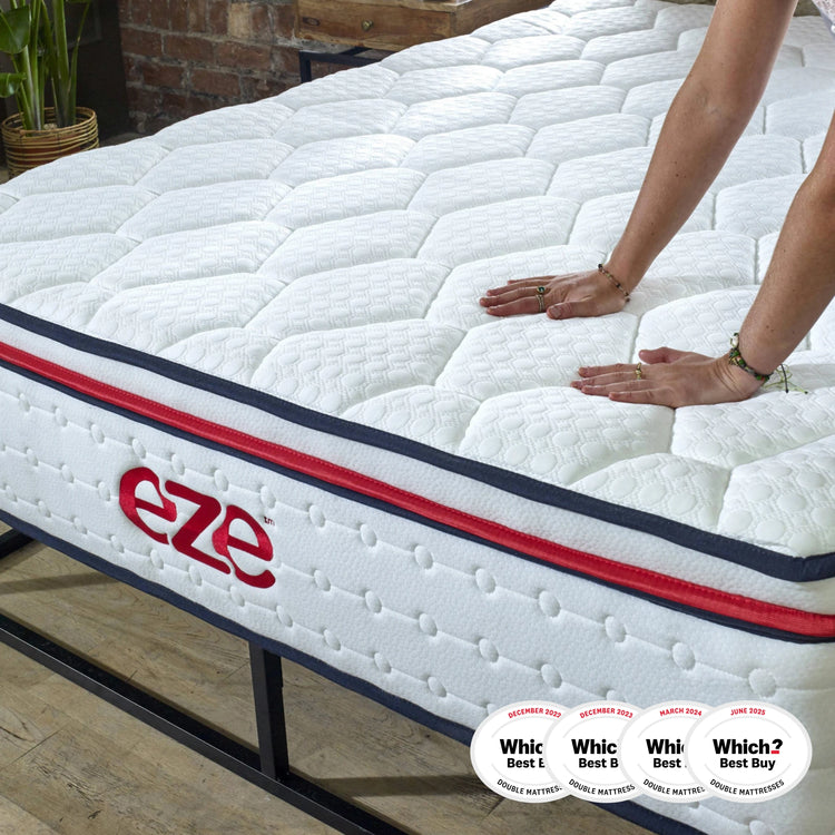 eze™ Hybrid Max Mattress on a black metal bed frame with a person pressing down to show firmness; awarded Which? Best Buy 2023 for double mattresses.