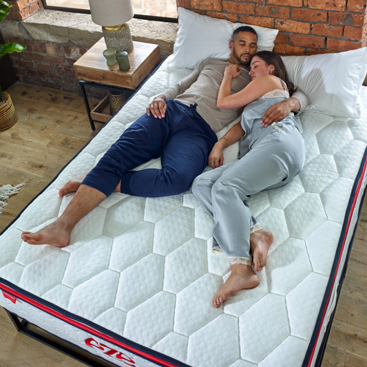 couple laying on an eze hybrid max mattress