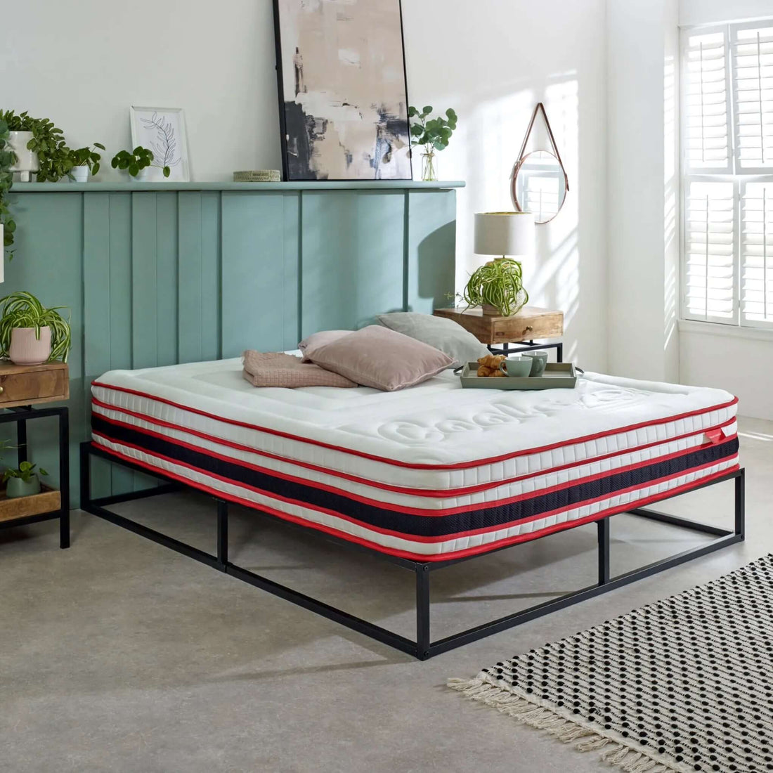 cooleze hybrid original mattress styled on a vynal floor with a sage headboard, plants and matching bedside tables 