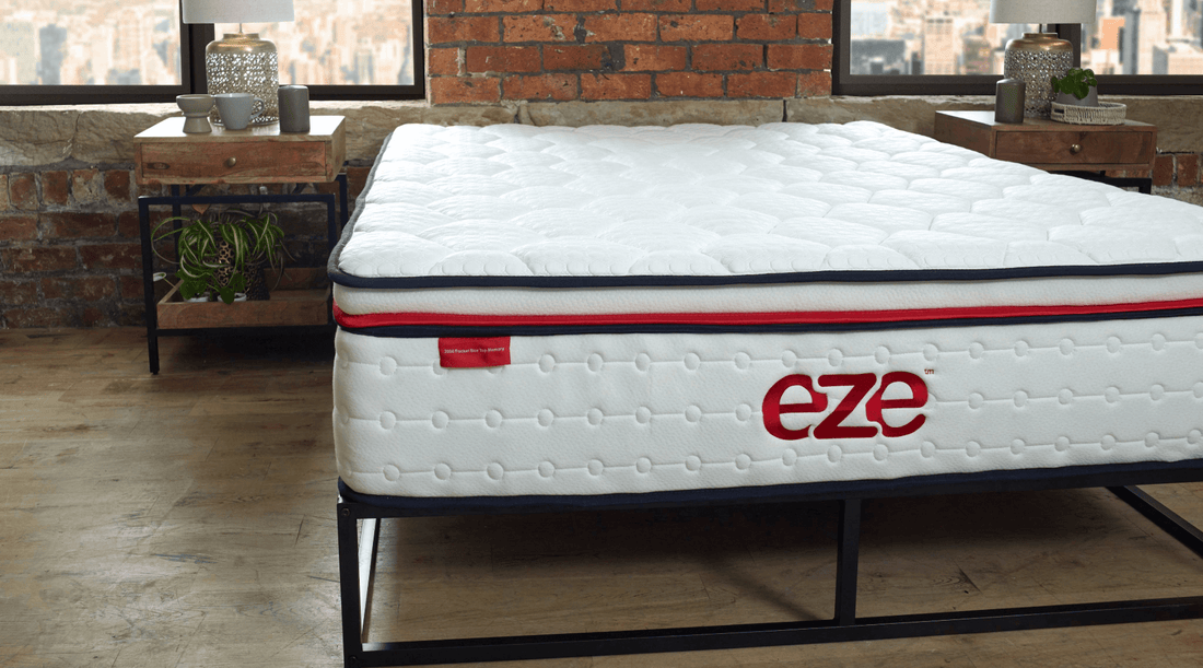 eze hybrid max mattress unstyled on a wooden floor with a brick wall backdrop