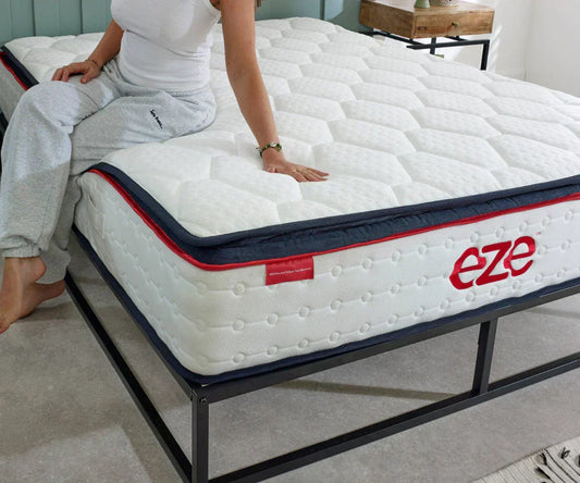 eze hybrid ultra soft mattress with women sat on bed touching the surface