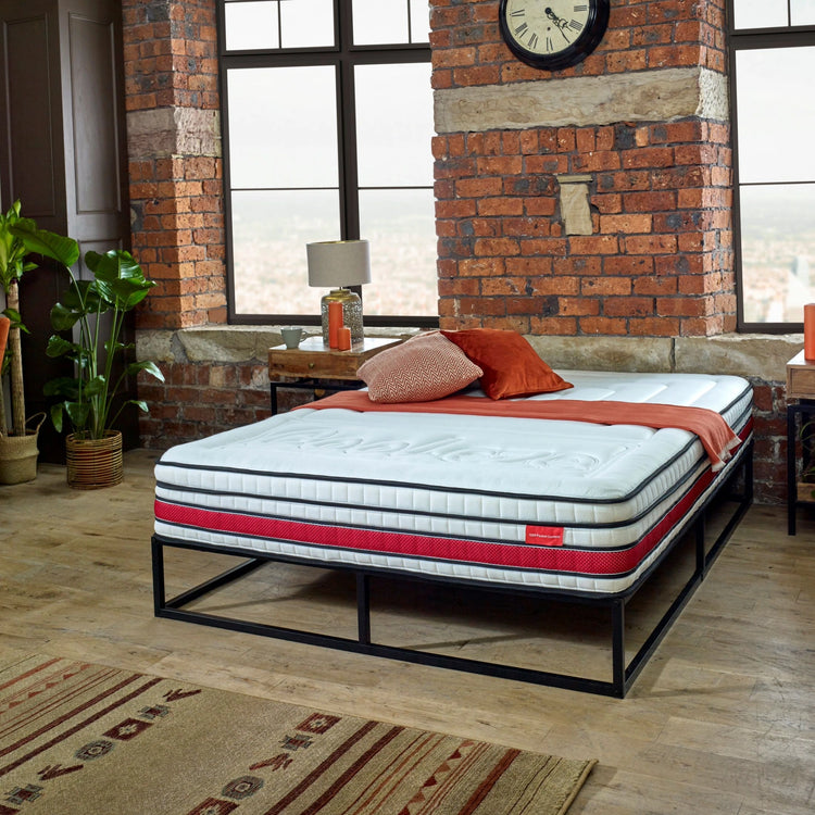 EZE_DELUXE_HYBRID_MATTRESS_ROOM_STYLED_ORANGE_AND_BRICKWALL_MATTRESS_ON_BED_WITH_THROWS_AND_CUSHIONS