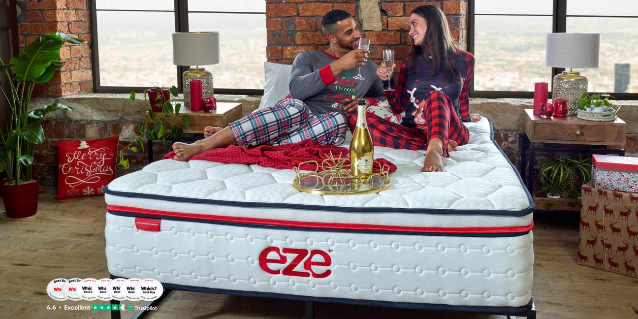 couple on eze mattress with champagne glasses in a christmas setting with which logos