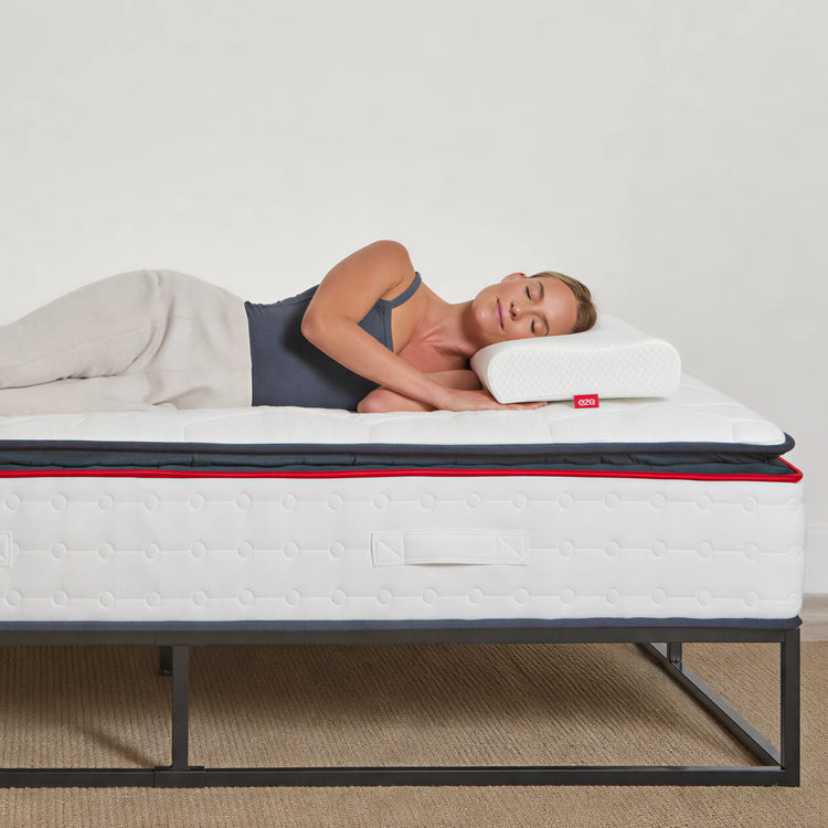 women lying on a hybrid mattress with a visible eze brand logo, on a plain background